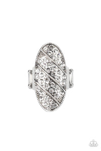Rows of glassy white rhinestones slant across a stretched oval frame dotted in silver studs, creating a dramatic centerpiece atop the finger. Features a stretchy band for a flexible fit.  Sold as one individual ring.